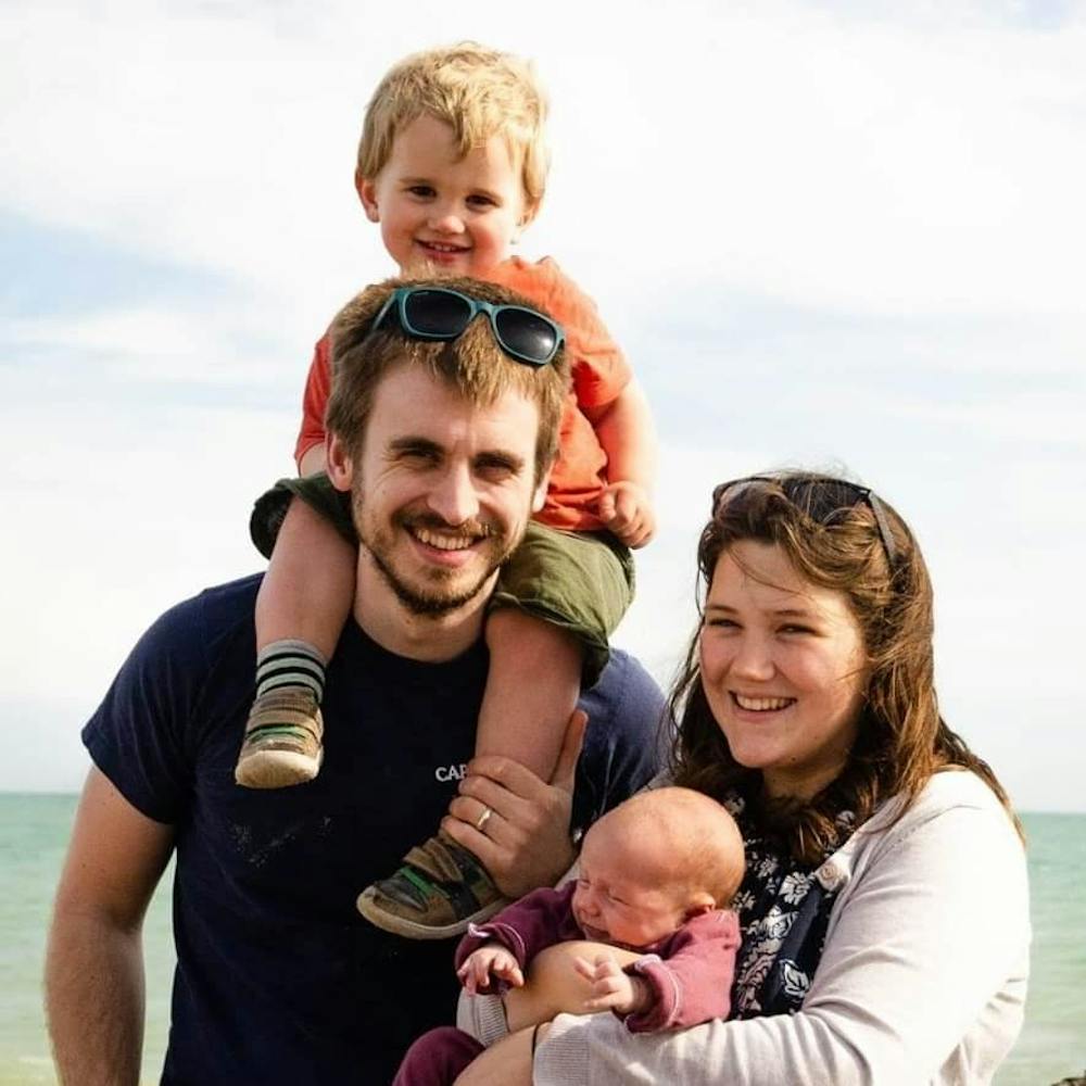 Family Photo by the sea of Birch and Tides with husband and wife and two little children | Cheerfully Given